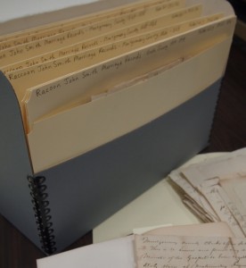 Folders containing documents placed into archival safe box for proper storage.